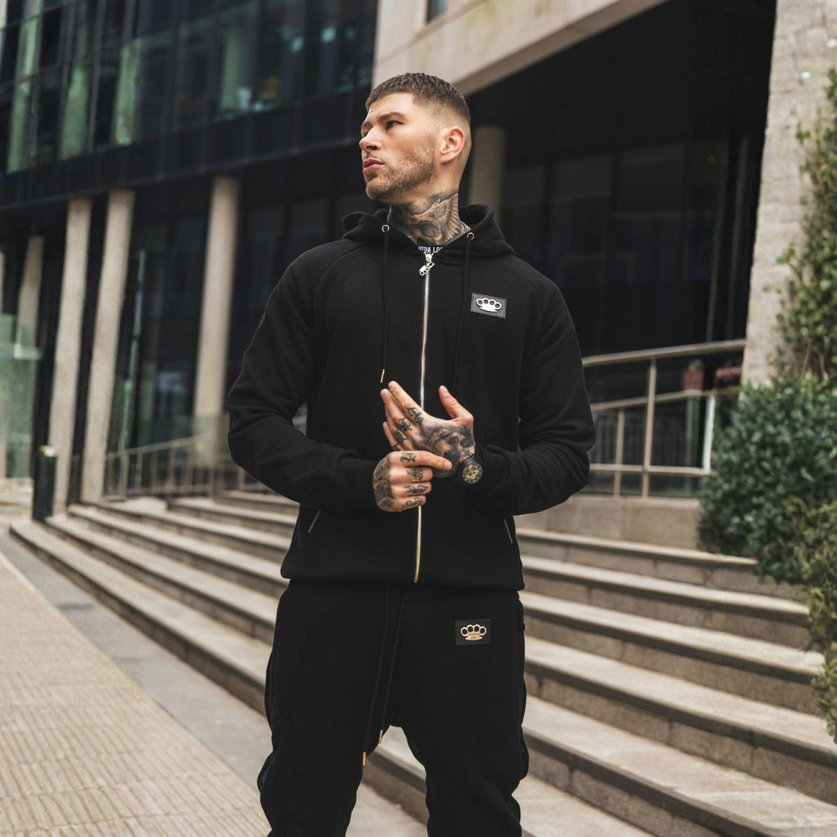 Jogger LFR Tracksuit nero indossato da modello con la felpa LFR, busto e patch logo in vista