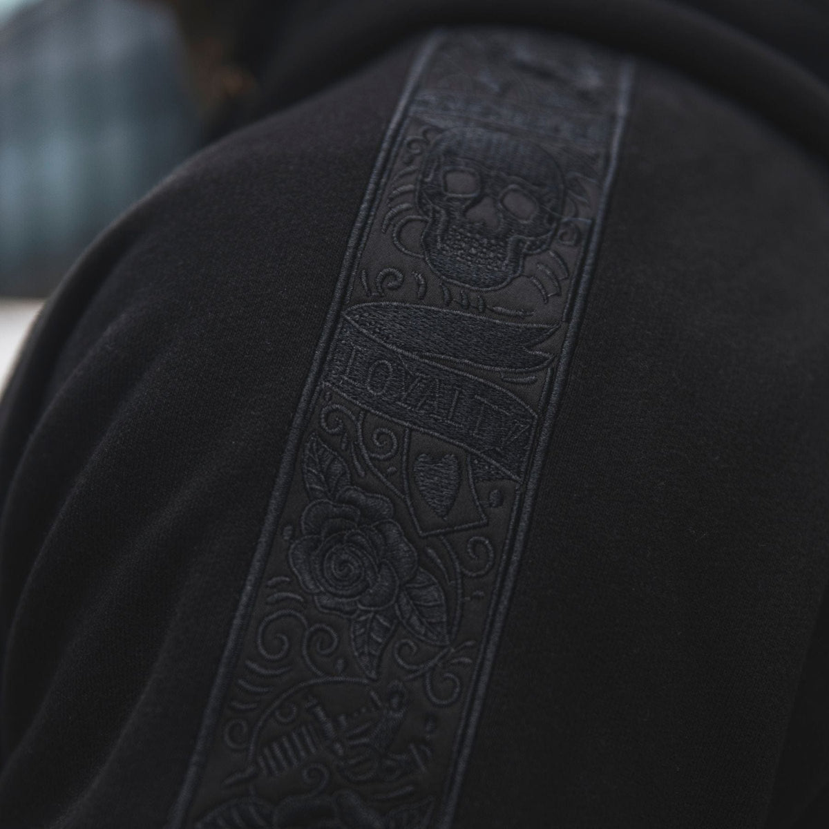 Close-up van de zwarte LFR embroidery band met schedel op de schouder van de hoodie