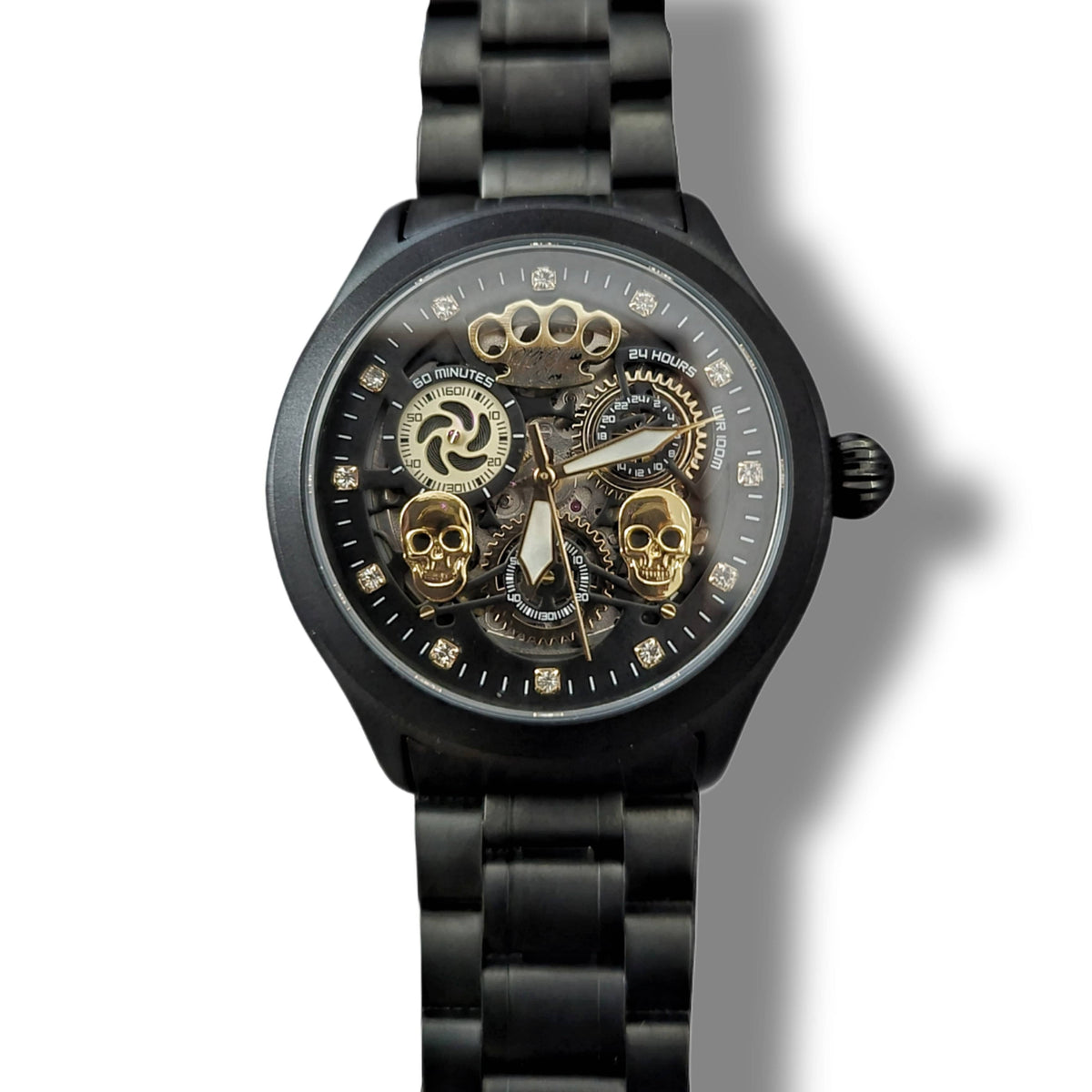 Frontal del reloj Double skull negro mate con dos calaveras doradas y mecanismo a la vista