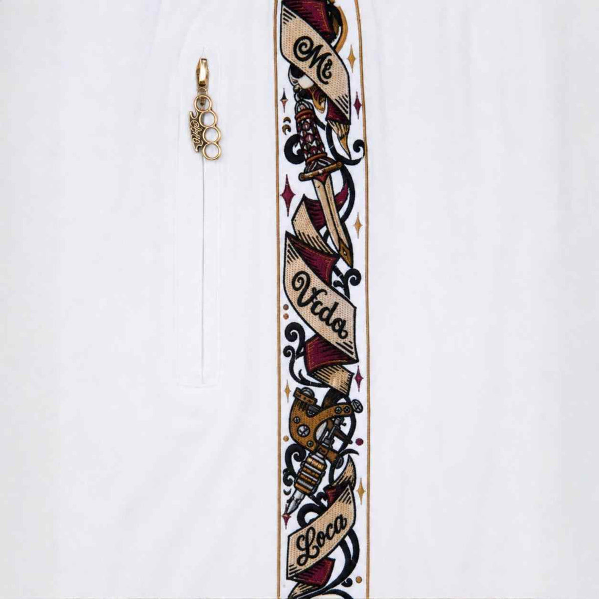 Close-up van de Savage ornate band met Mi Vida Loca banner en rits met gouden MVL logo hanger