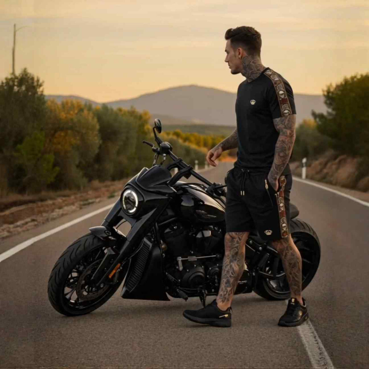 Calavera T-shirt zwart met bijpassende korte broek gedragen door model naast een motor bij zonsondergang