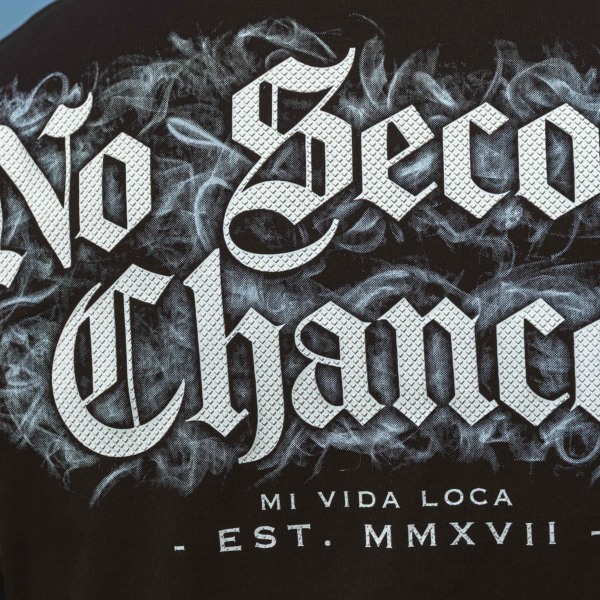 Zbliżenie nadruku No second chances na plecach z dymem i napisem Mi Vida Loca Est. MMXVII