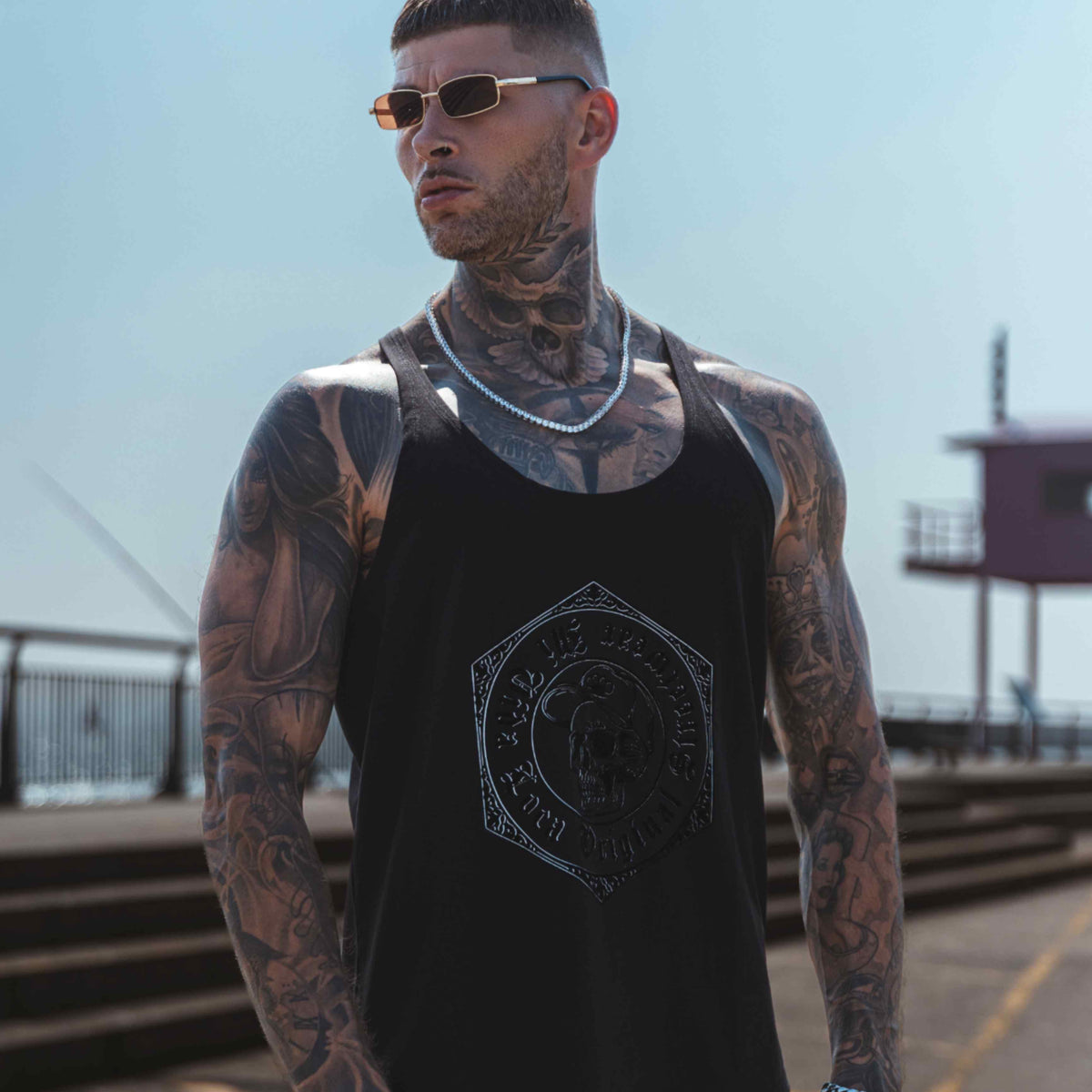 Tank top MVL Original streetwear czarny na modelu na nabrzeżu, fotografowany od dołu