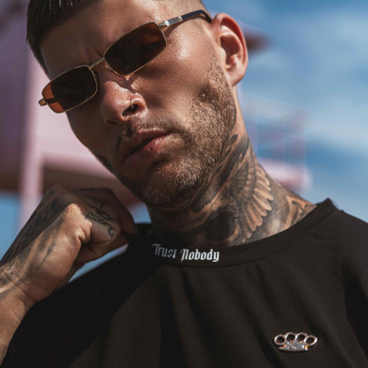 Close-up van de Trust nobody tekst in de nek en het MVL logo op het zwarte T-shirt, gedragen