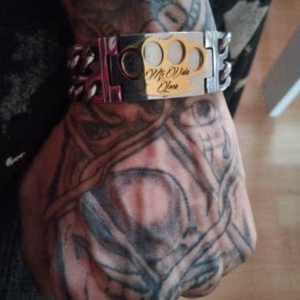 Close-up of the MVL bracelet with gold MVL logo and Mi Vida Loca engraving on the wrist