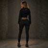 Achterkant van het zwarte MVL Meander dames trainingspak met cropped hoodie, gedragen door model